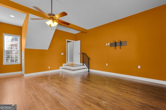 unfurnished living room with ceiling fan, wood-type flooring, and vaulted ceiling