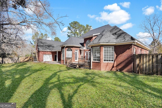 rear view of house with a wooden deck and a lawn