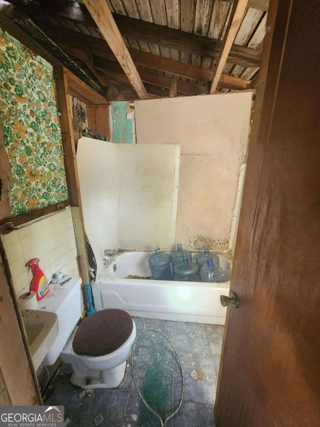 bathroom with a washtub and toilet