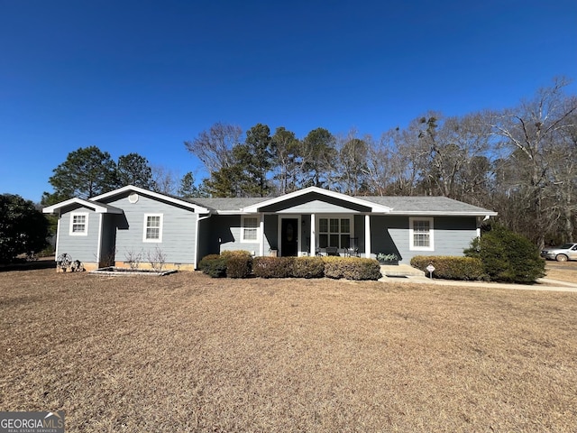 ranch-style house featuring a front yard and covered porch