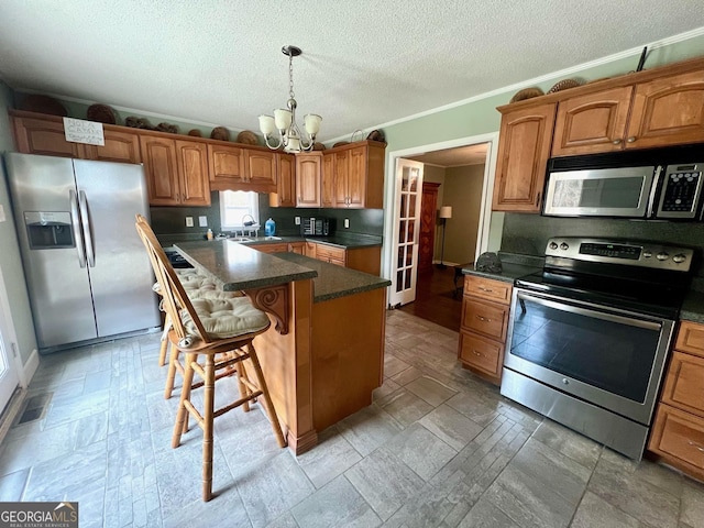 kitchen featuring sink, a kitchen breakfast bar, a center island, a notable chandelier, and stainless steel appliances