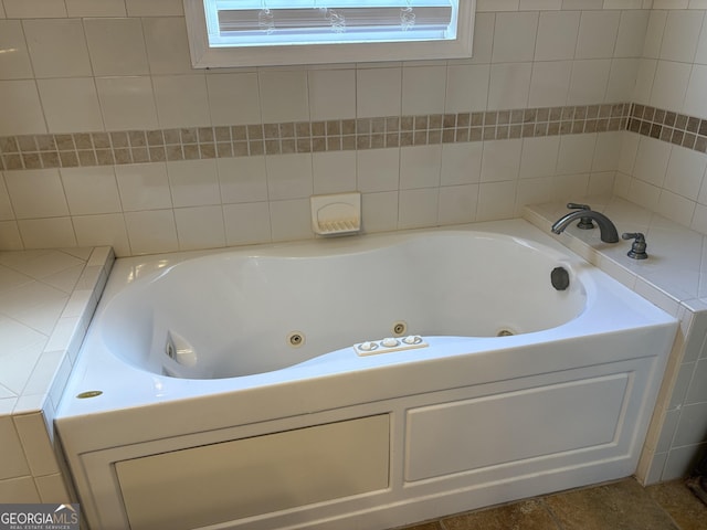 bathroom featuring plenty of natural light and a tub to relax in