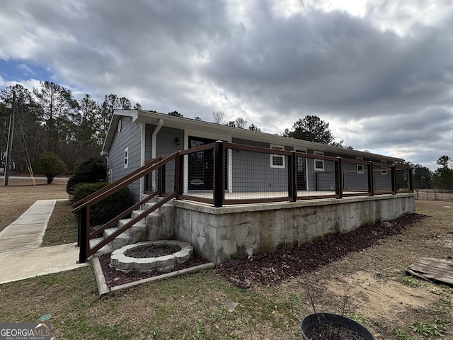 view of side of property with cooling unit and a fire pit