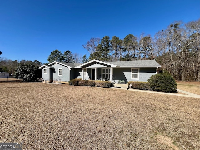 ranch-style home with a front yard and covered porch