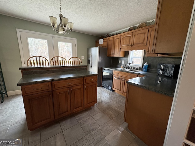 kitchen featuring sink, decorative light fixtures, a chandelier, a kitchen island, and black appliances