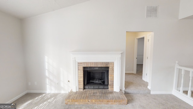 unfurnished living room featuring carpet flooring and a brick fireplace