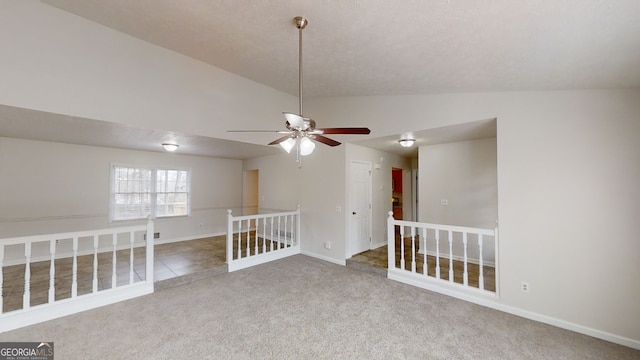 carpeted empty room featuring vaulted ceiling and ceiling fan