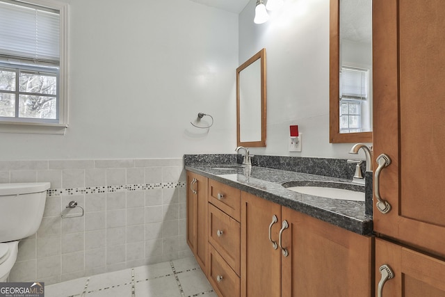 bathroom featuring tile walls, vanity, and toilet