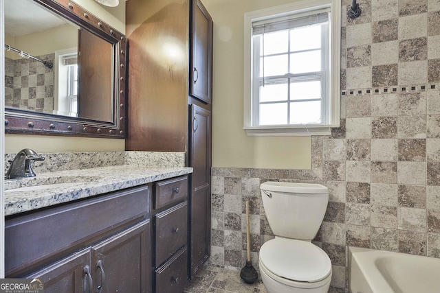 full bathroom with vanity, bathing tub / shower combination, tile walls, and toilet