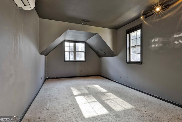 bonus room with light carpet and a wall unit AC