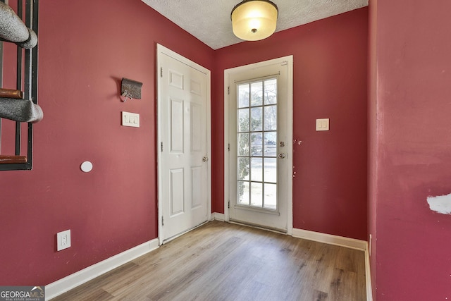 entryway with a healthy amount of sunlight, a textured ceiling, and light hardwood / wood-style floors