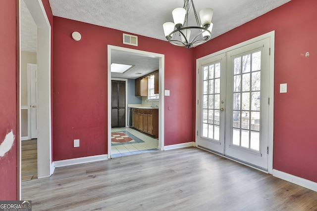 entryway featuring a wealth of natural light, french doors, and a textured ceiling