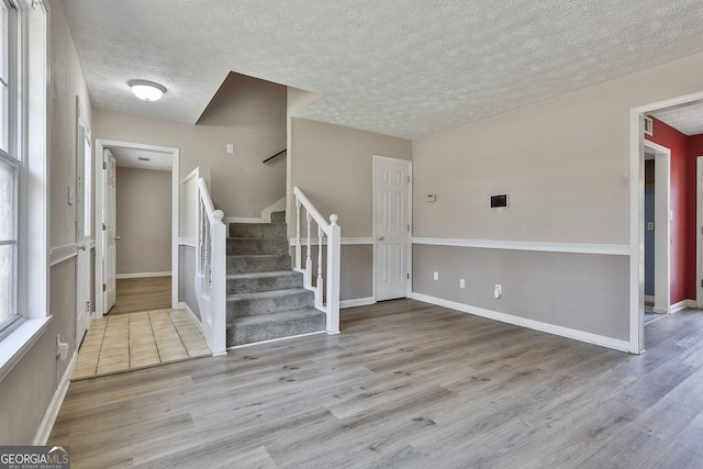 entryway with light hardwood / wood-style floors and a textured ceiling