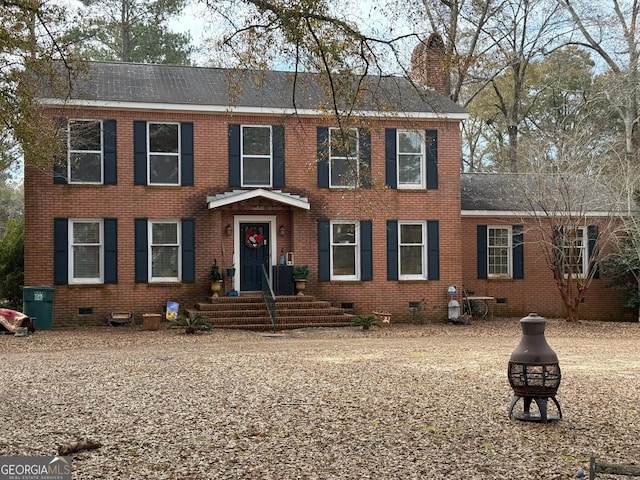 colonial inspired home with an outdoor fire pit