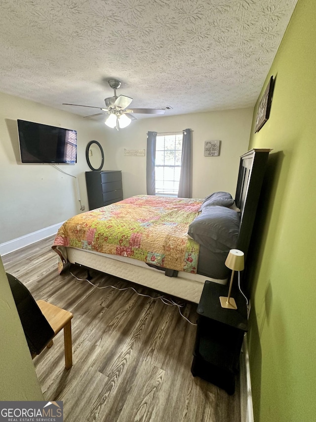 bedroom featuring hardwood / wood-style floors, a textured ceiling, and ceiling fan