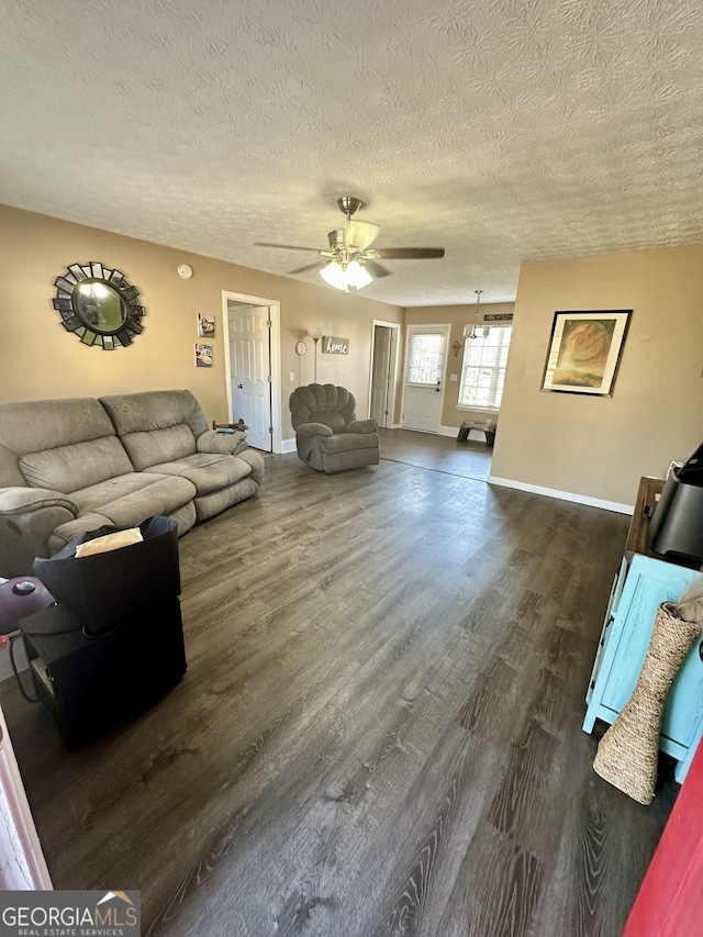 living room with ceiling fan, a textured ceiling, and dark hardwood / wood-style flooring