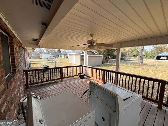 deck with a lawn, ceiling fan, and a shed