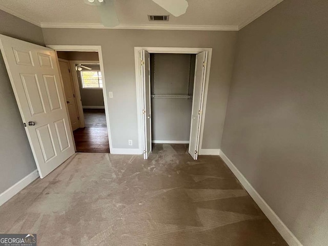 unfurnished bedroom featuring crown molding, carpet floors, and a closet