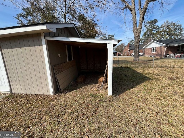 view of side of property featuring a carport and a lawn