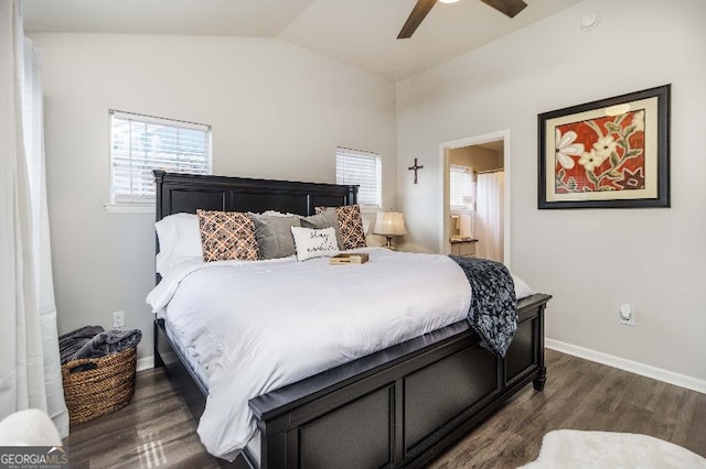 bedroom with lofted ceiling, dark wood-type flooring, multiple windows, and ensuite bath