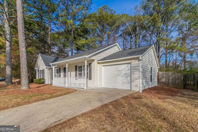 ranch-style home featuring a porch, a garage, and a front lawn