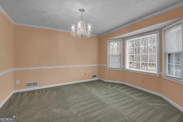 carpeted spare room with ornamental molding and a chandelier