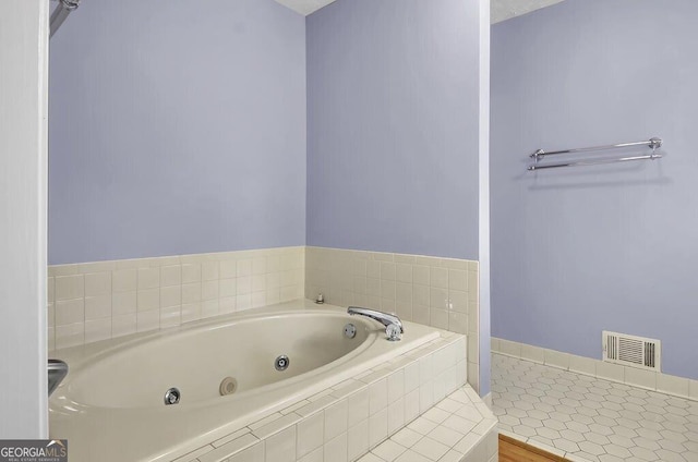 bathroom with a relaxing tiled tub and tile patterned floors