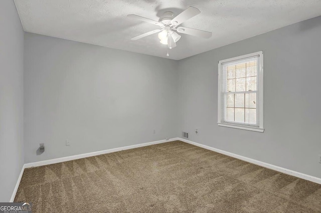 carpeted spare room with a textured ceiling and ceiling fan