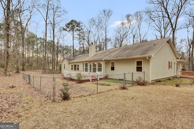 back of property with a wooden deck and a lawn