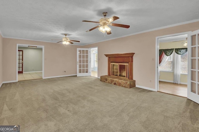 unfurnished living room featuring crown molding, light colored carpet, and french doors