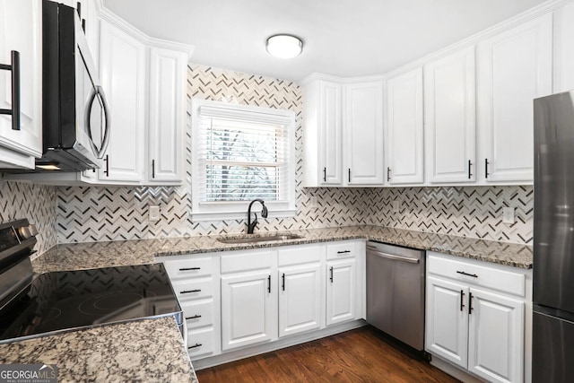 kitchen featuring white cabinets, stainless steel appliances, stone counters, and sink