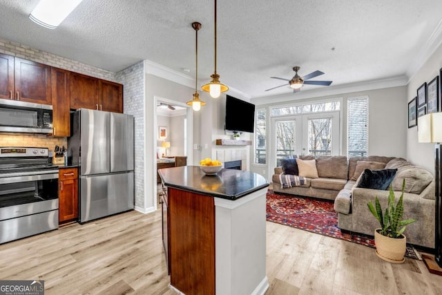 kitchen with french doors, crown molding, pendant lighting, stainless steel appliances, and light hardwood / wood-style floors