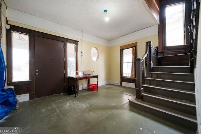 foyer featuring ornamental molding and a textured ceiling