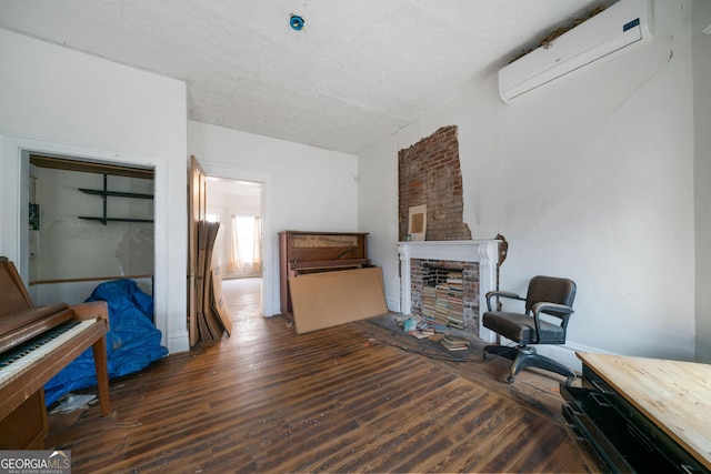 living room featuring dark wood-type flooring, a wall mounted air conditioner, and a fireplace