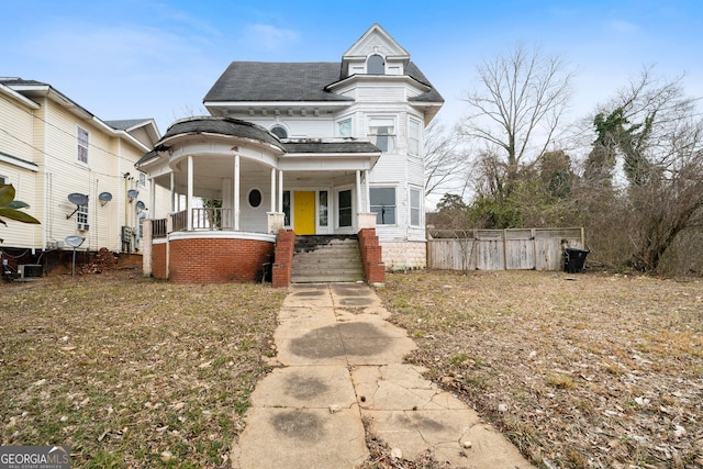 victorian-style house with cooling unit and a porch