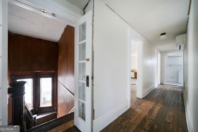 hall featuring french doors, dark hardwood / wood-style flooring, and wood walls