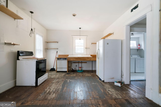 kitchen featuring dark hardwood / wood-style flooring, pendant lighting, washing machine and clothes dryer, and white appliances