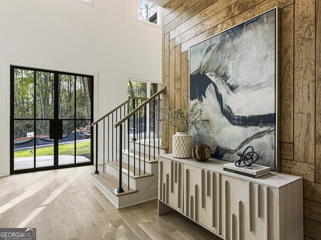 interior space featuring light hardwood / wood-style floors, french doors, and a high ceiling