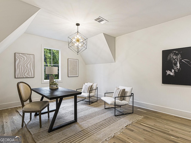 living area featuring an inviting chandelier, hardwood / wood-style floors, and lofted ceiling