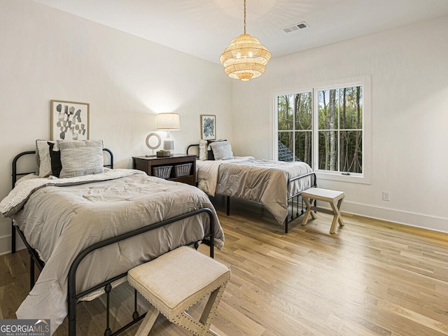 bedroom featuring light hardwood / wood-style flooring and a notable chandelier