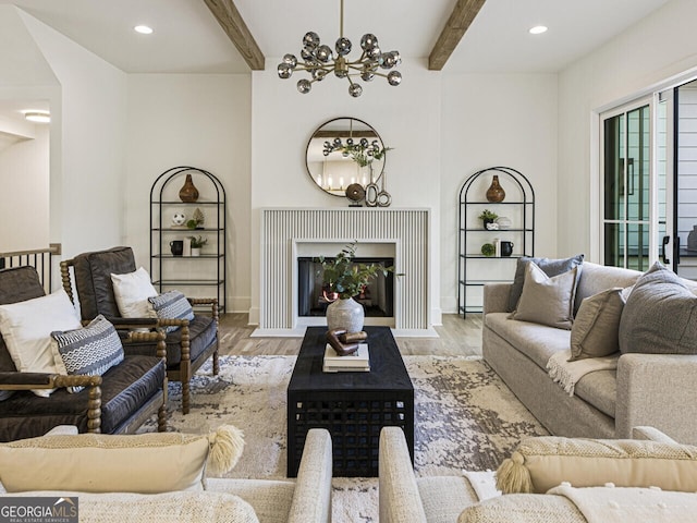 living room featuring beamed ceiling, light hardwood / wood-style floors, and a chandelier