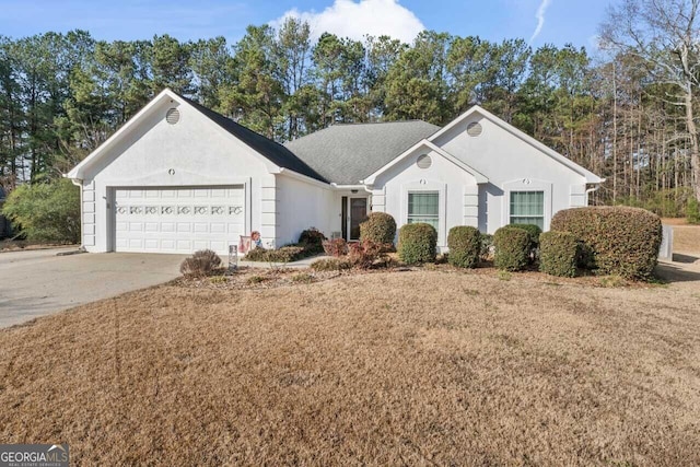 ranch-style house featuring a garage and a front lawn