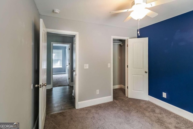 unfurnished bedroom with ceiling fan and dark carpet