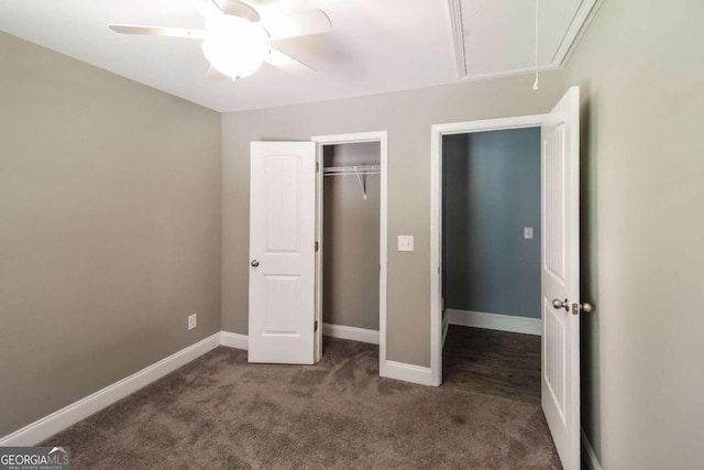 unfurnished bedroom featuring ceiling fan, dark carpet, and a closet