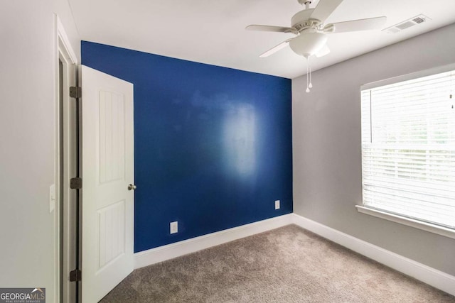 spare room with ceiling fan and carpet