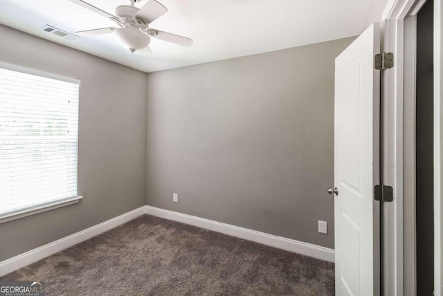 carpeted spare room with ceiling fan