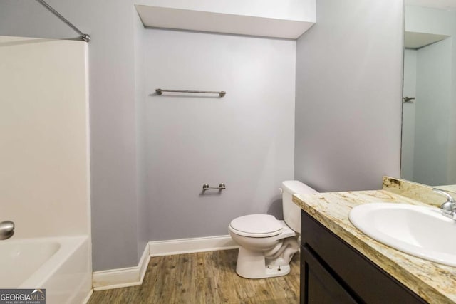 bathroom featuring wood-type flooring, toilet, and vanity