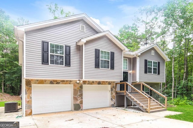 split foyer home with a garage and central AC unit