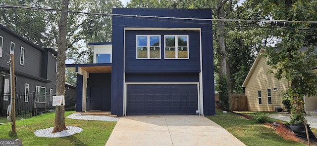 contemporary house featuring a garage and a front lawn