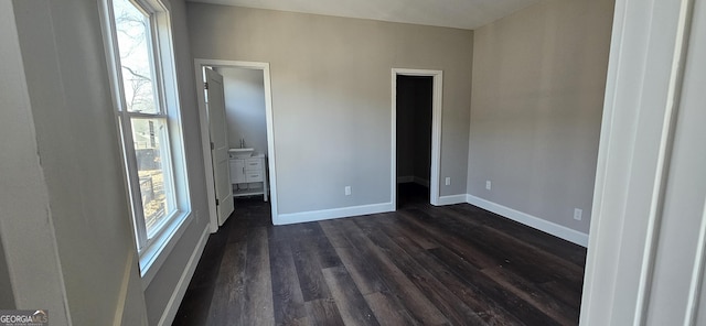 unfurnished bedroom featuring dark wood-type flooring and multiple windows